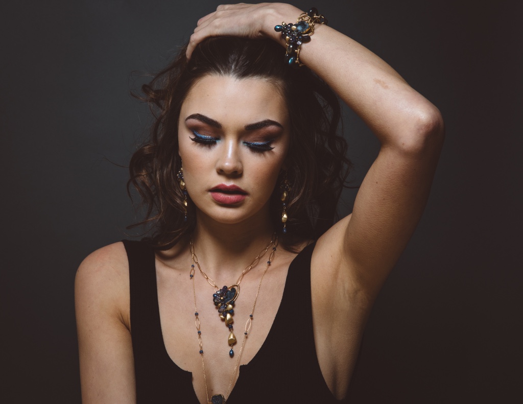 model wearing gemstone and gemstone gold drop pendant necklace