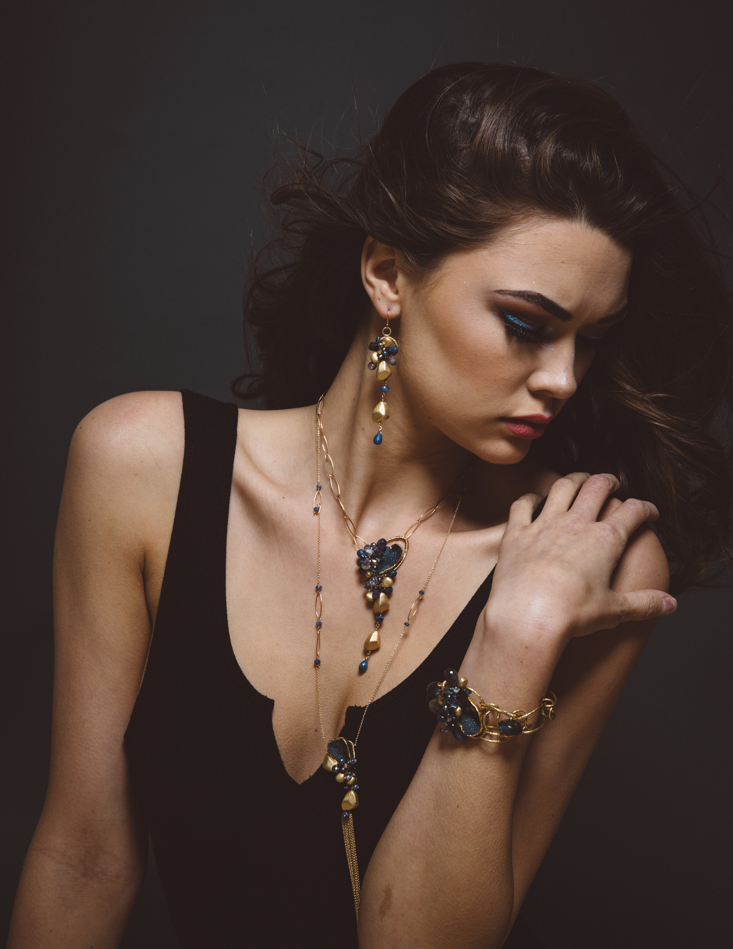 model wearing gemstone and gemstone gold drop pendant necklace