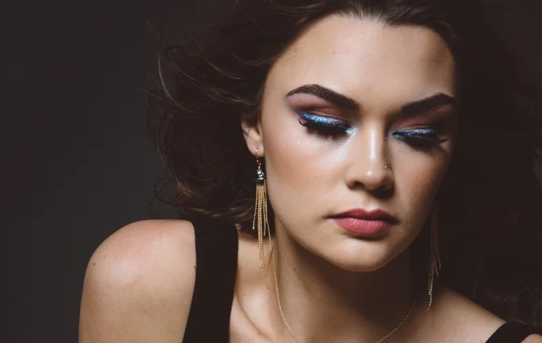 model wearing fancy cut trillion quartz gold chain tassel earrings