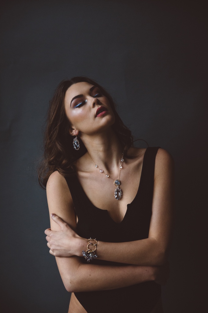 model wearing sapphire encrusted quartz pendant earrings