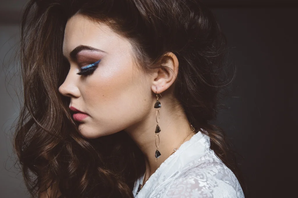 model wearing fancy trillion cut quartz triple drop gold earrings