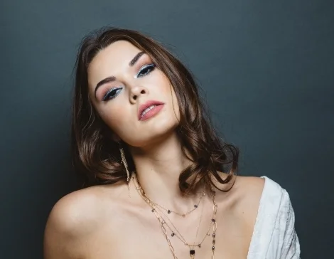 model wearing emerald cut iolite multi briolette gold chain tassel earrings