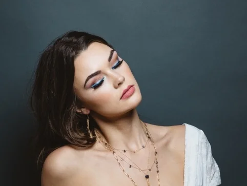 model wearing emerald cut iolite multi briolette gold chain tassel earrings