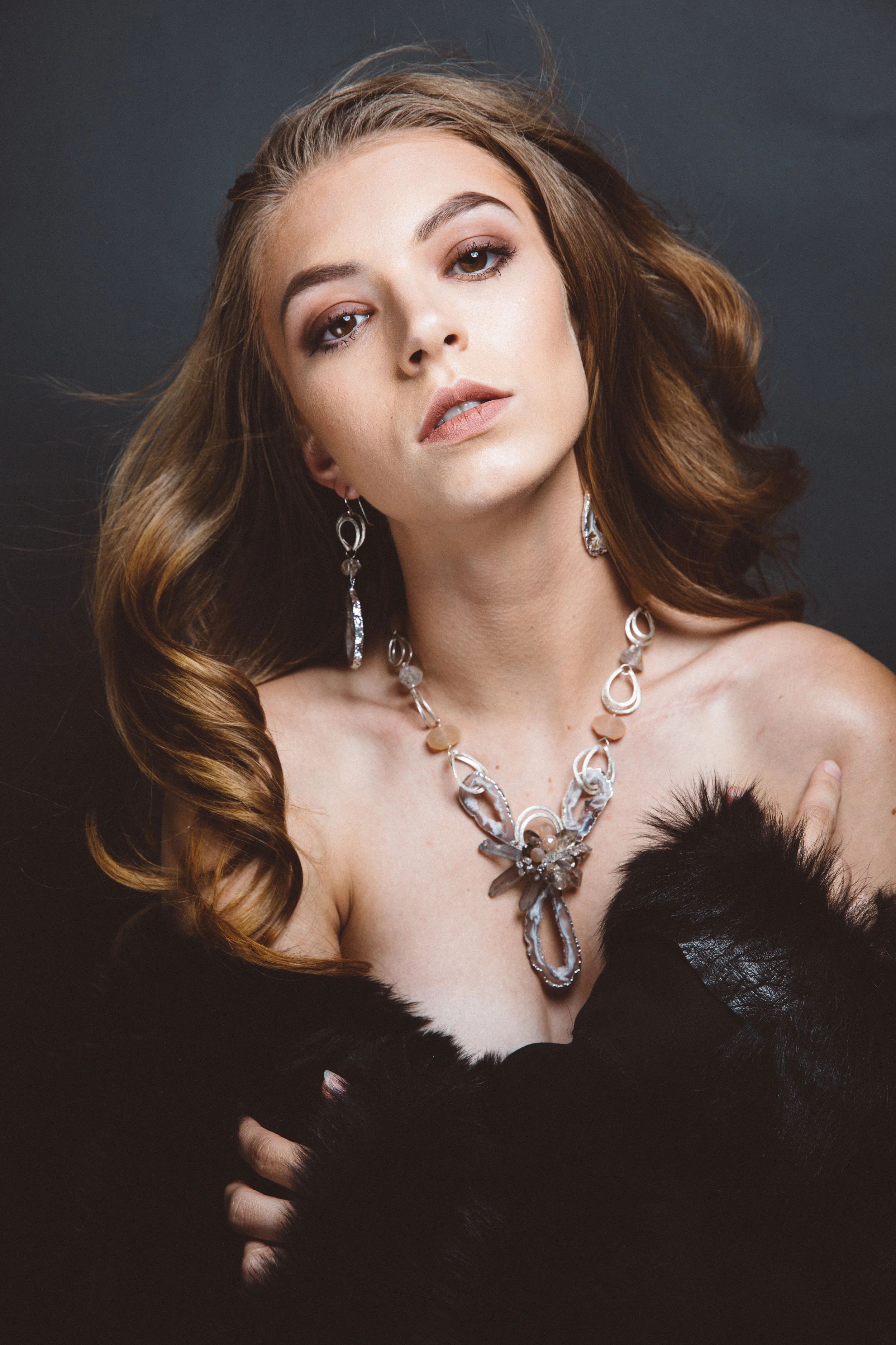 model wearing sliced geode pendant necklace with gemstones and sterling silver