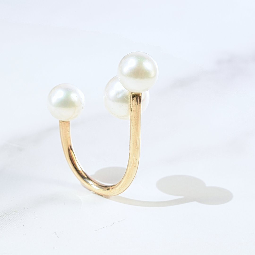 etailed view of the Statement Gold Three Pearl Floating Illusion Ring's setting, focusing on the precision and beauty of its floating illusion.