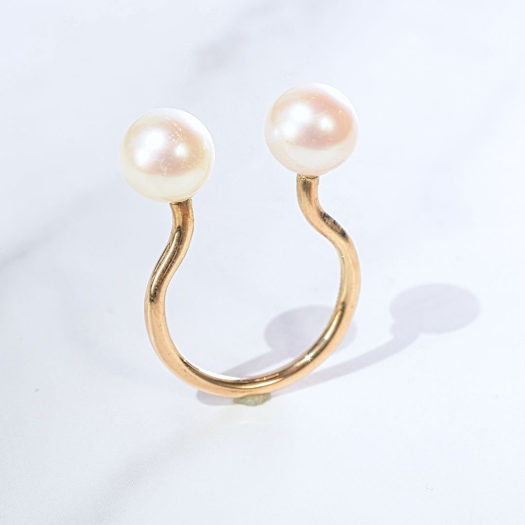 Side angle of the trendy and modern gold open ring band with pearls, capturing the shimmer of gold and the glow of pearls