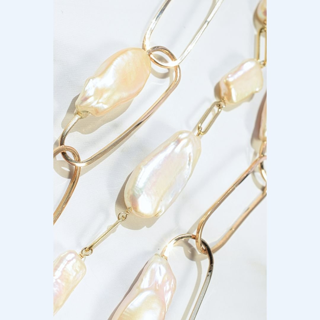 Zoomed-in section of the Baroque Pearl and Gold Multi-Strand Link Necklace, focusing on the unique texture of the baroque pearls against the gold links