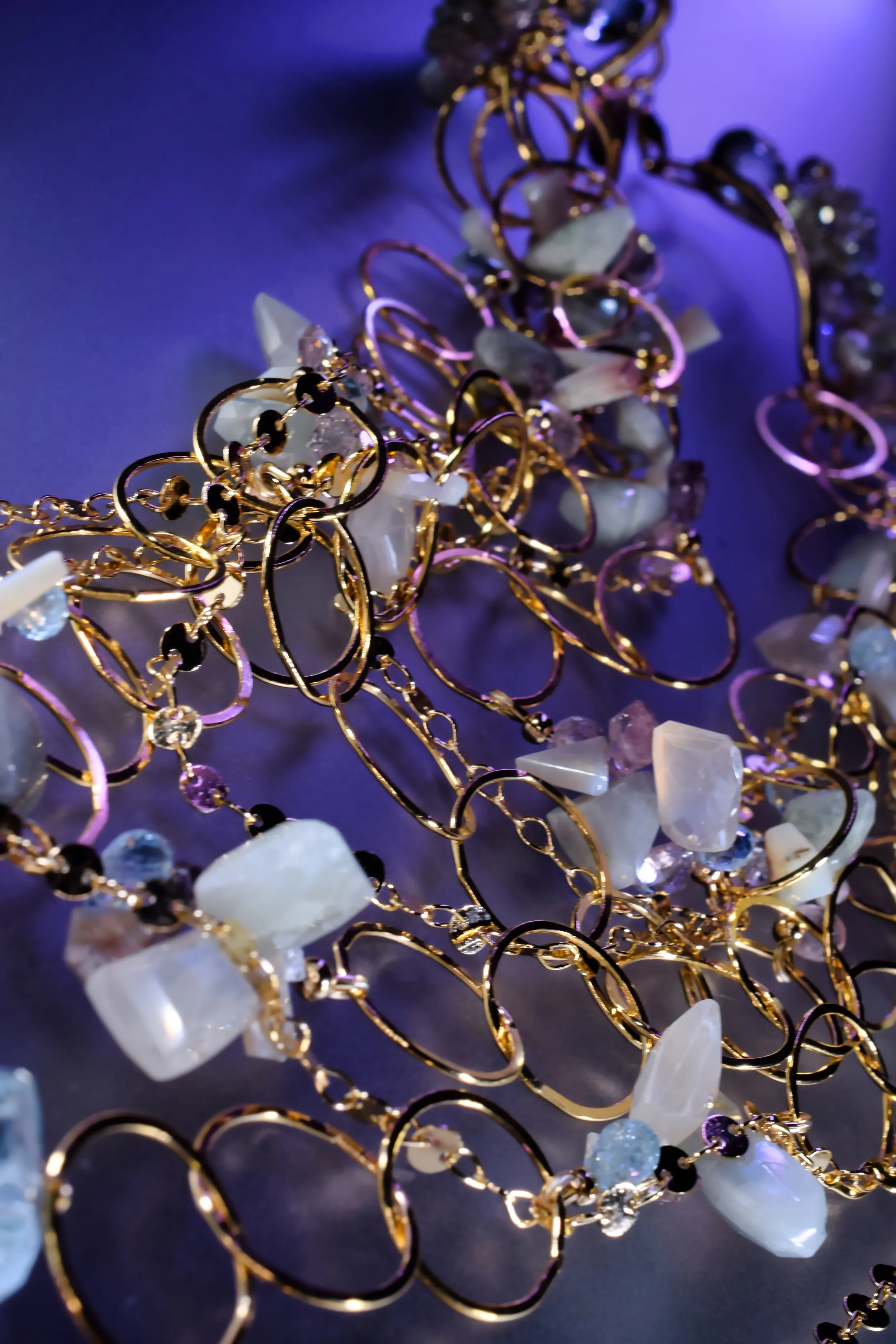 multi-chain statement necklace details with gold link chains and pastel gemstones