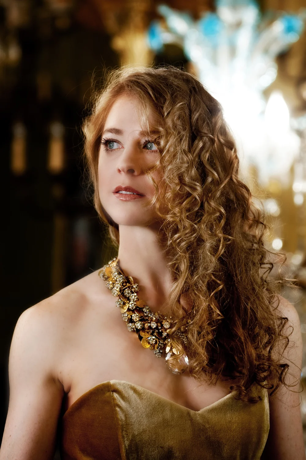 Blonde woman in gold dress with necklace