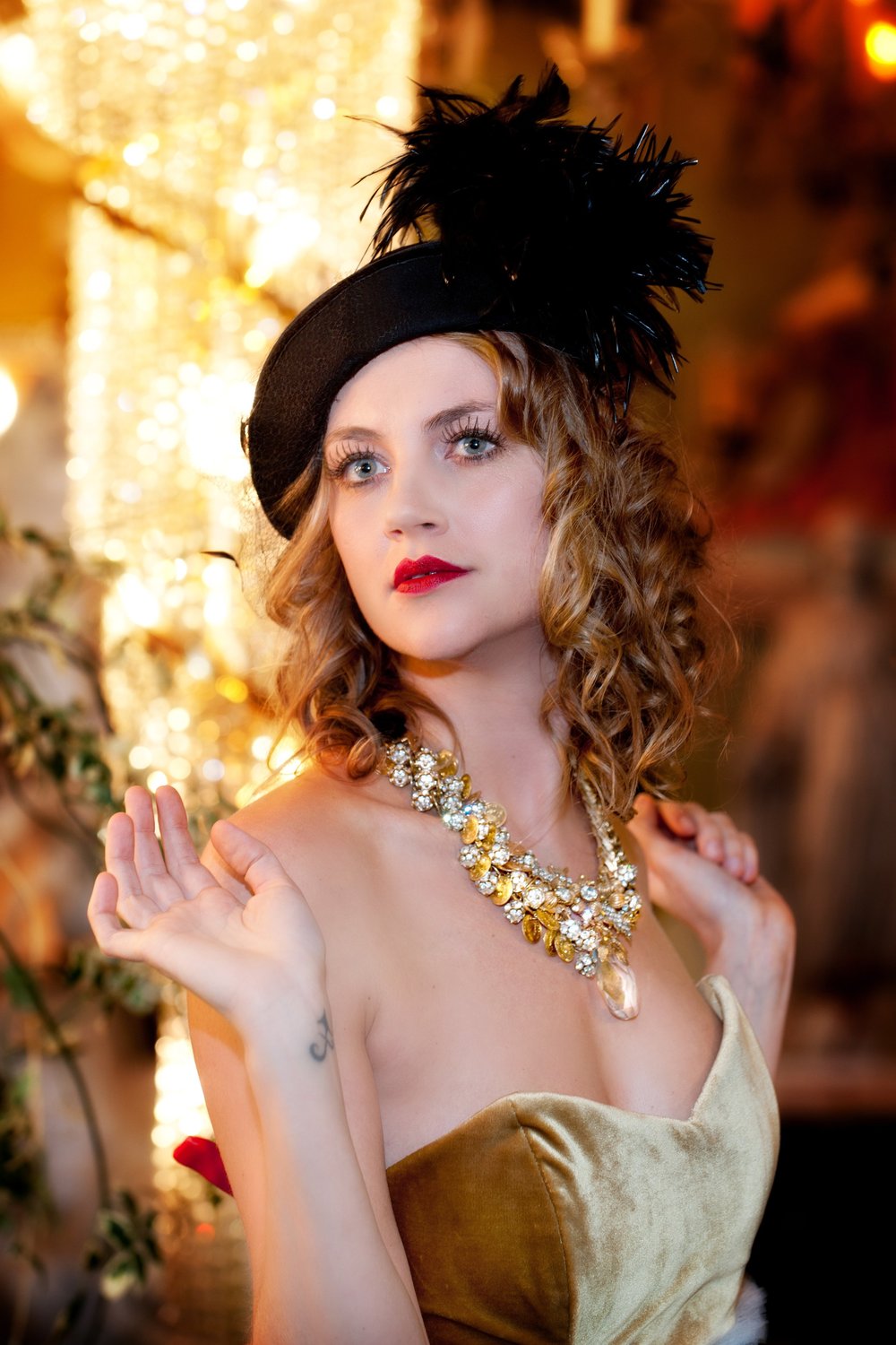 Woman with hat in vintage dress with gold necklace
