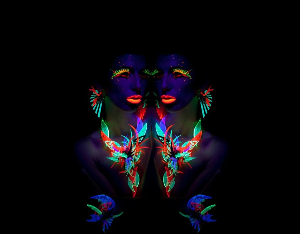 Woman in blue dress and colorful art jewelry and blacklight