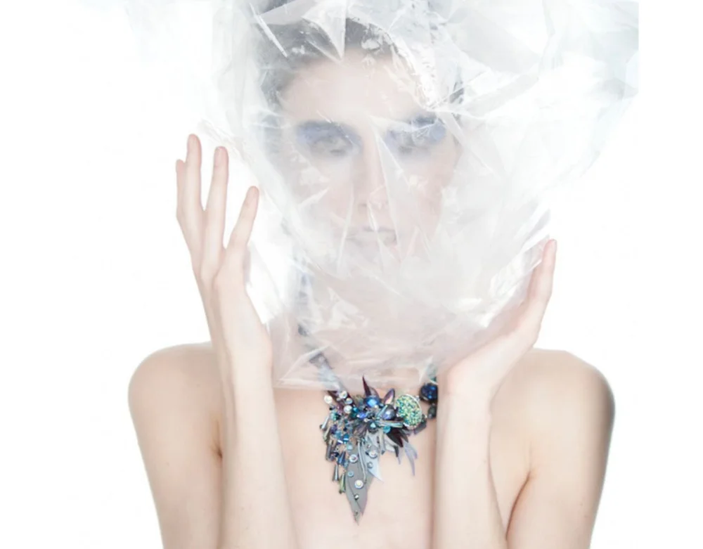 Woman in blue dress and colorful art jewelry and white background