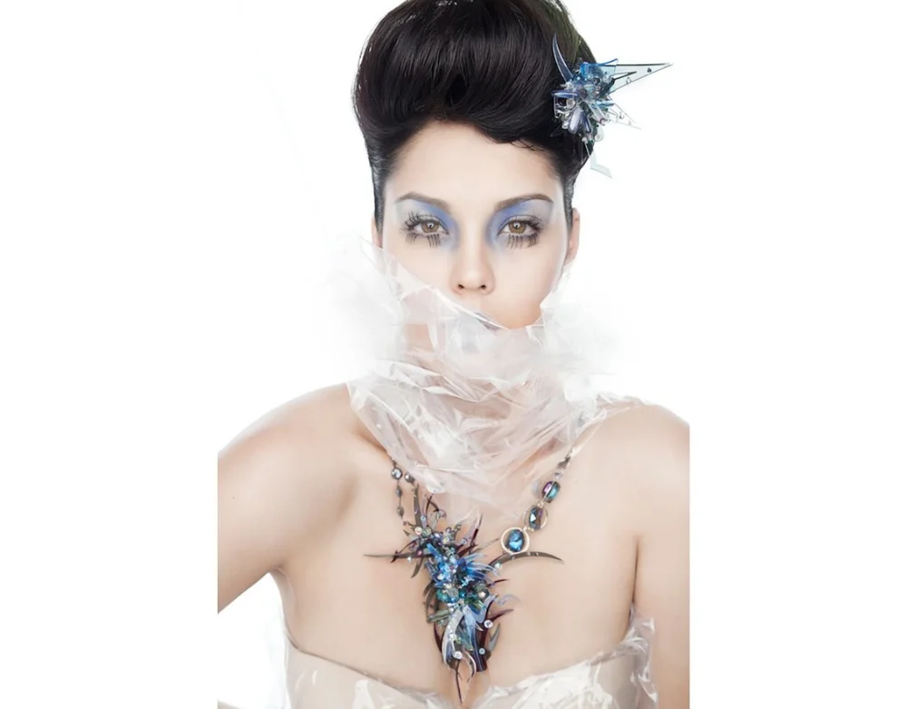 Woman in blue dress and colorful art jewelry and white background