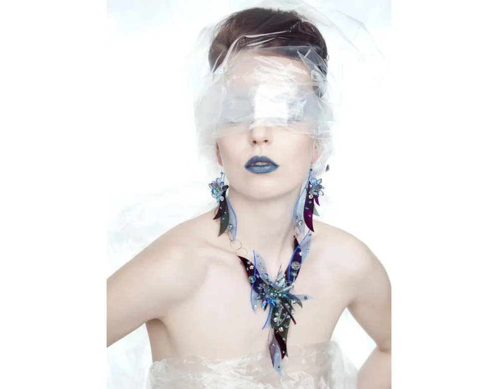 Woman in blue dress and colorful art jewelry and white background