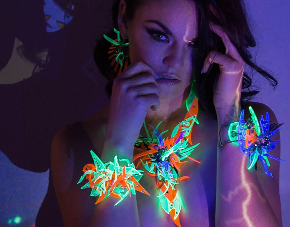 Woman wearing colorful art jewelry under blacklight