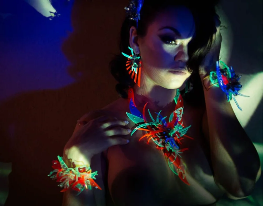 Woman wearing colorful art jewelry under blacklight