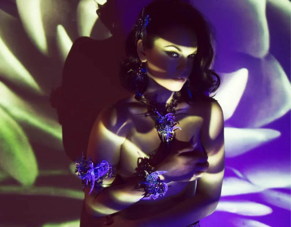 Woman wearing colorful art jewelry under blacklight