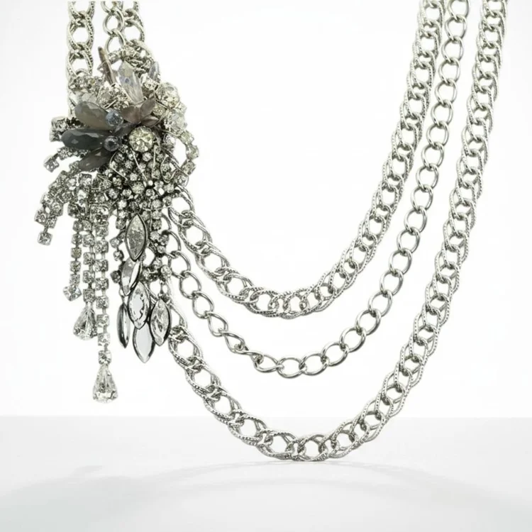 Multi-strand silver chain necklace with a dark crystal spray at one side