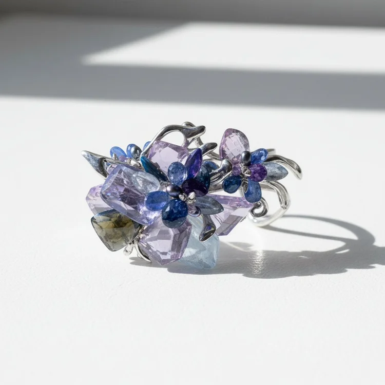 A cuff of violet and blue faceted stones and silver wire