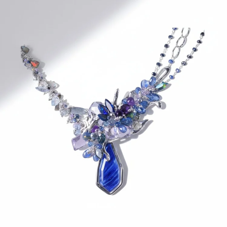 A statement necklace of violet, blue and clear stones with a deep blue drop