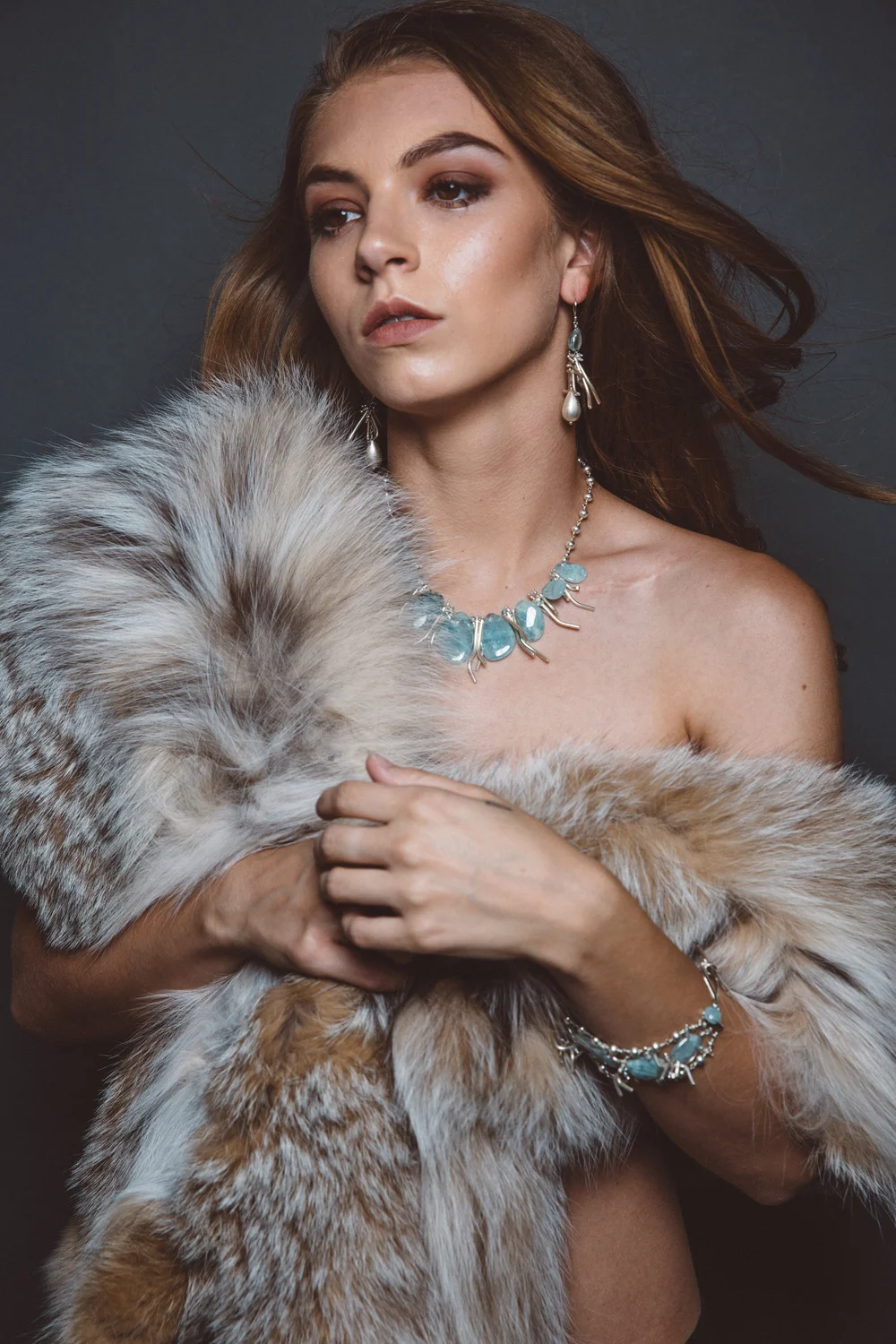 Caitlin wearing Andrea Li's aquamarine jewelry for the Piscine collection, in fur