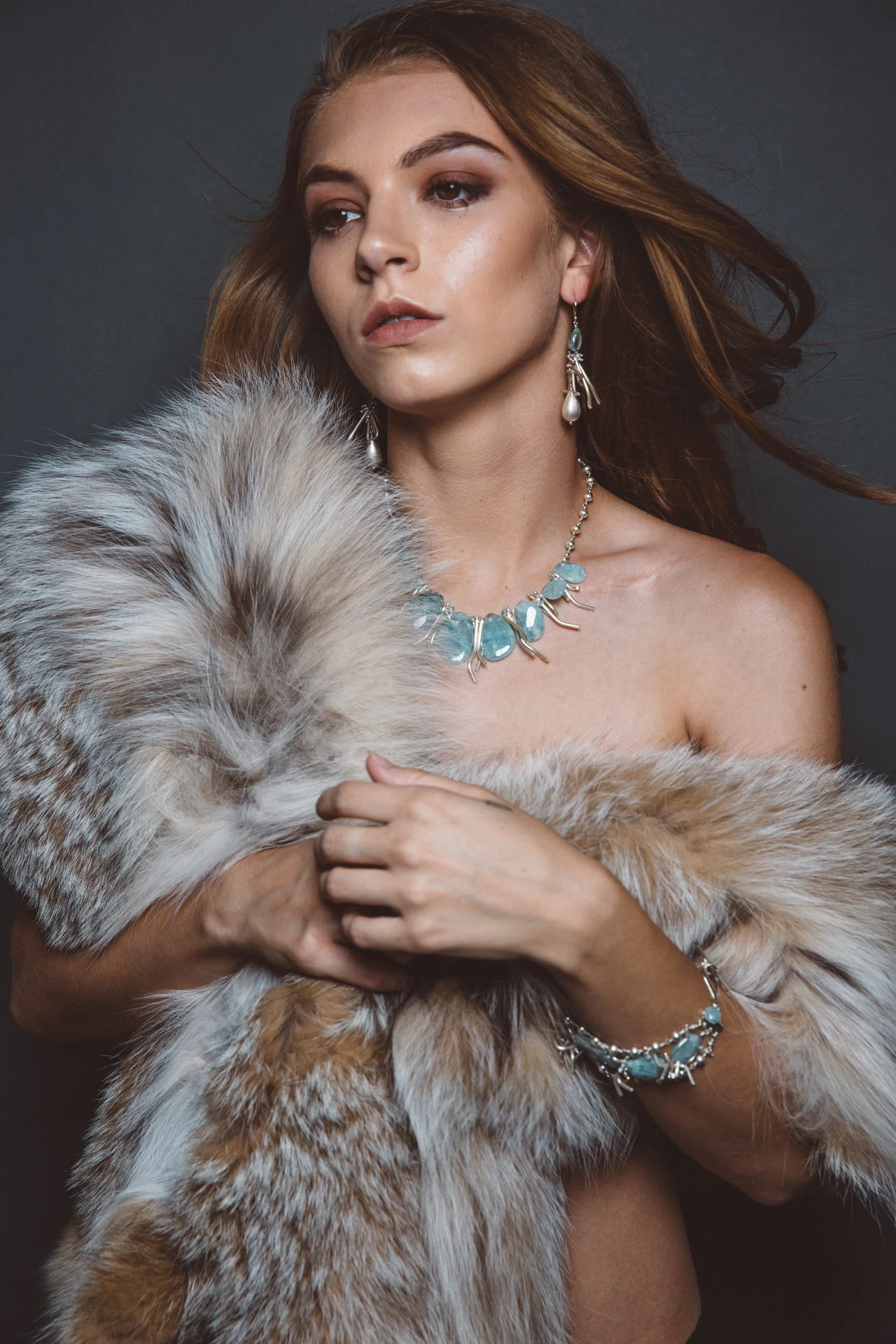 Caitlin wearing Andrea Li's aquamarine jewelry for the Piscine collection, in fur