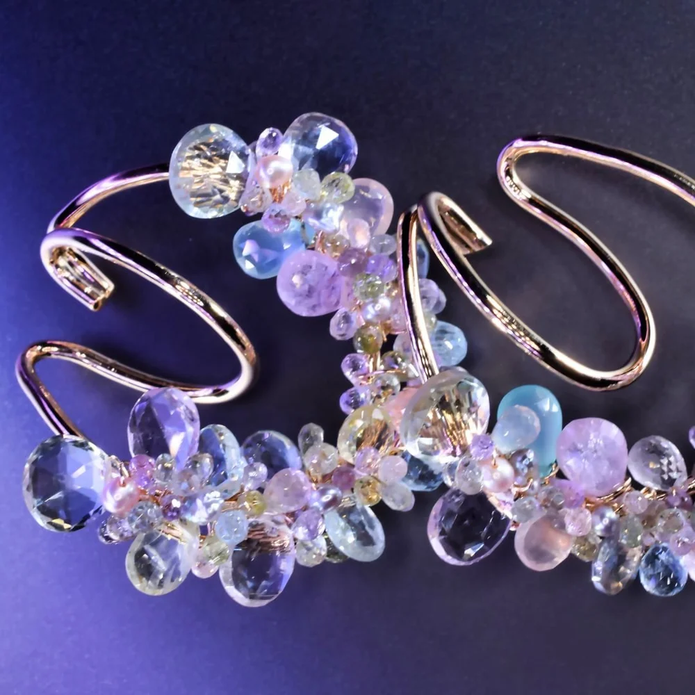 A pastel gemstone ear cuff from the Tamar collection by Andrea Li, on purple
