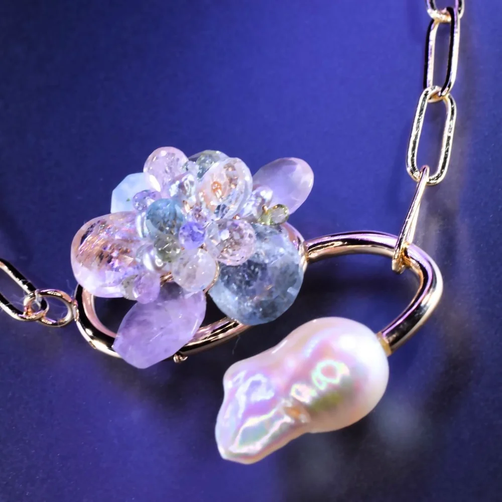 A pastel gemstone cluster necklace from the Tamar collection by Andrea Li, on purple