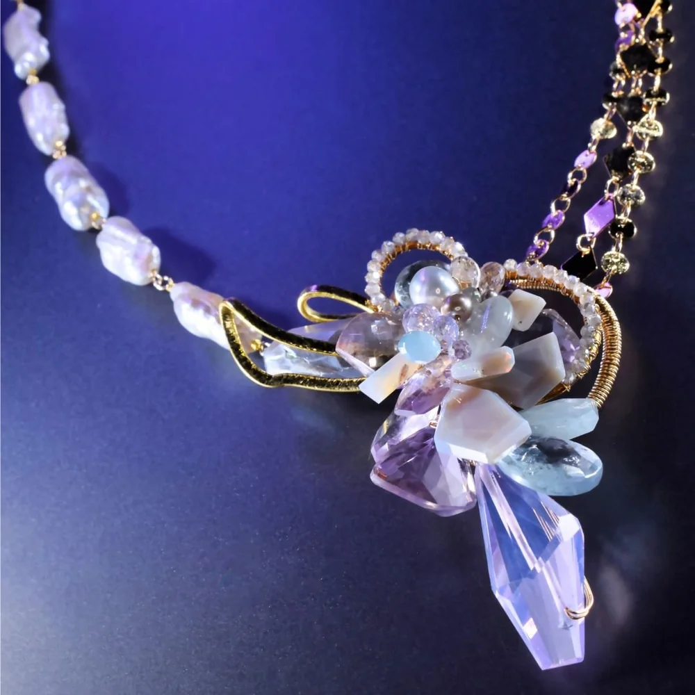 A pastel gemstone cluster necklace from the Tamar collection by Andrea Li, on purple