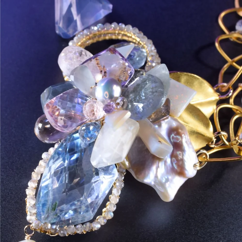 A pastel gemstone cluster necklace from the Tamar collection by Andrea Li, on purple