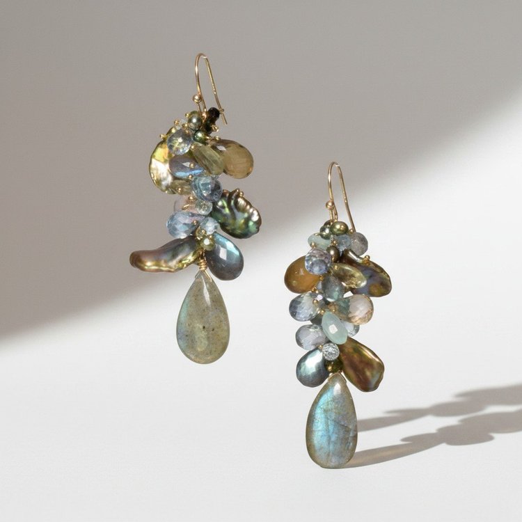 Gold earrings with cascades of gray, blue and green stones and gold leaves above iridescent teardrops