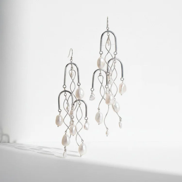 Silver chandelier earrings of tiered wire arches hung with white pearls