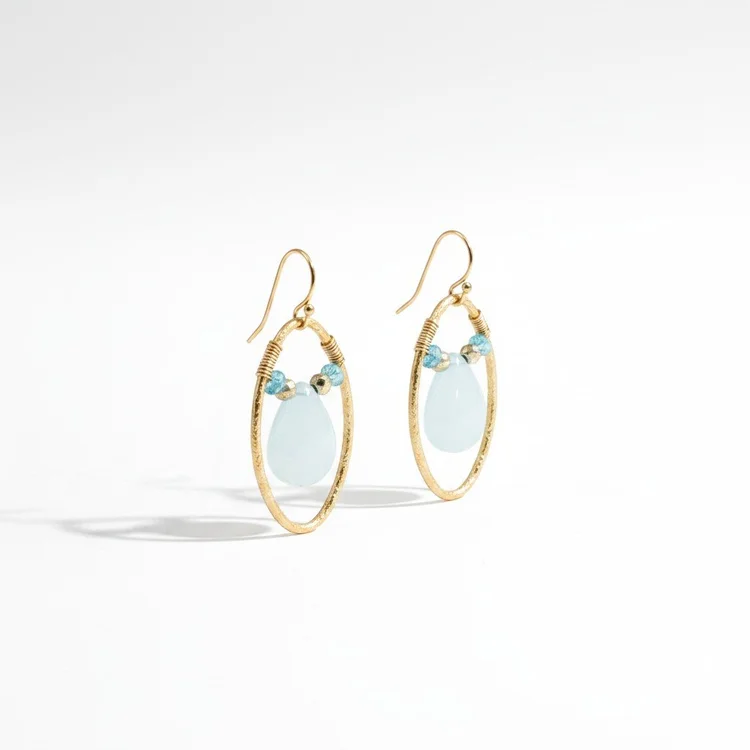 Gold oval hoop earrings with small blue stones and pale aqua teardrops