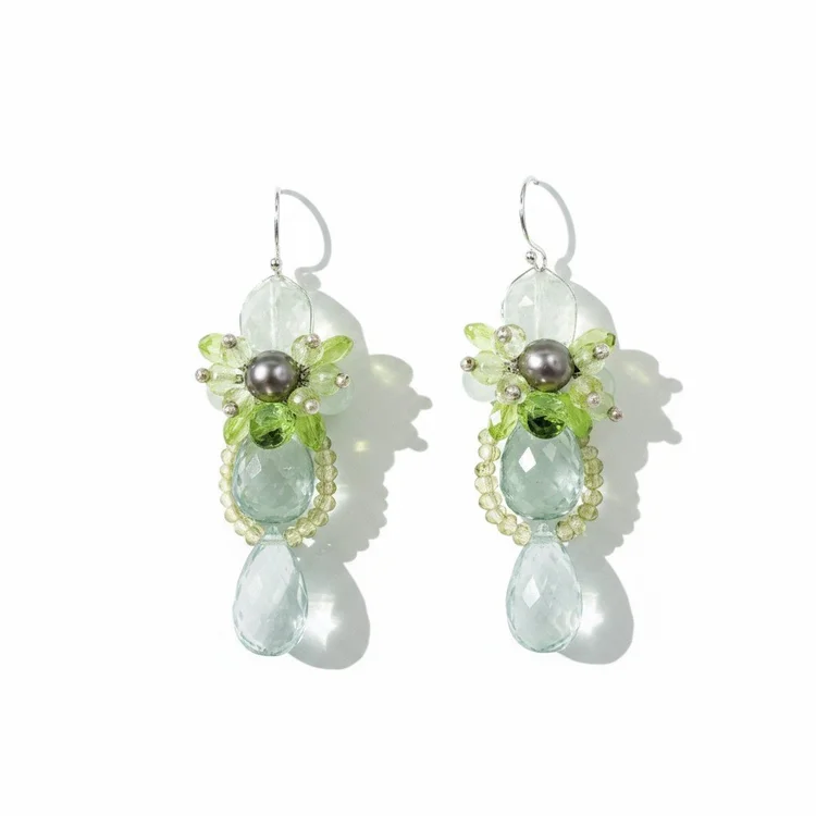Silver earrings with clusters of green stones and dark pearls above pale aqua drops
