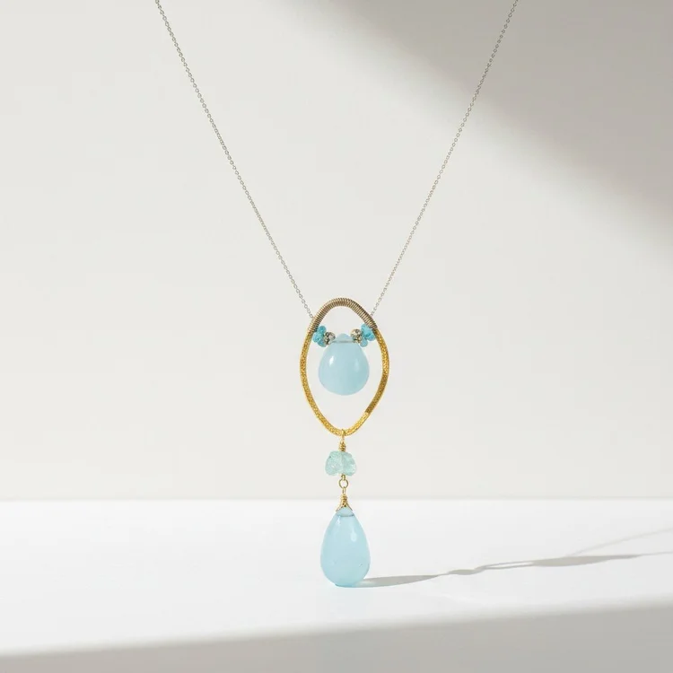 Fine gold chain with a gold marquise frame, a small blue stone and a pale aqua teardrop