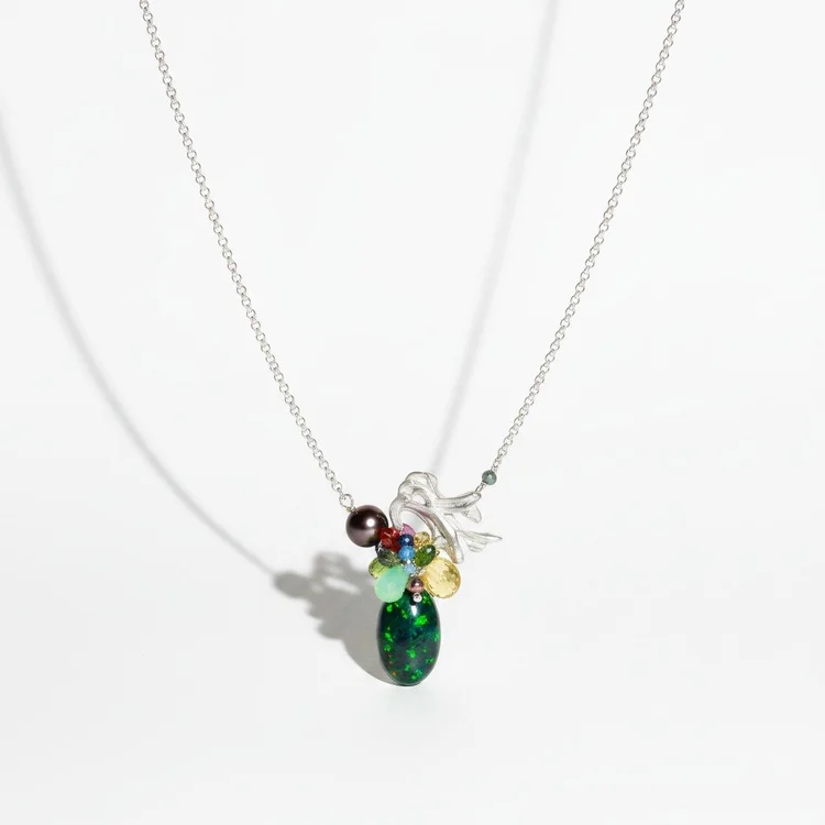 Fine silver chain with a small cluster of red and green stones above a deep green teardrop