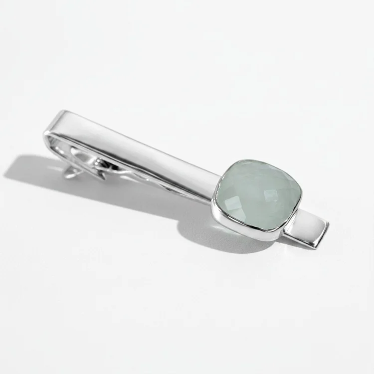 Silver tie bar with a pale green faceted stone