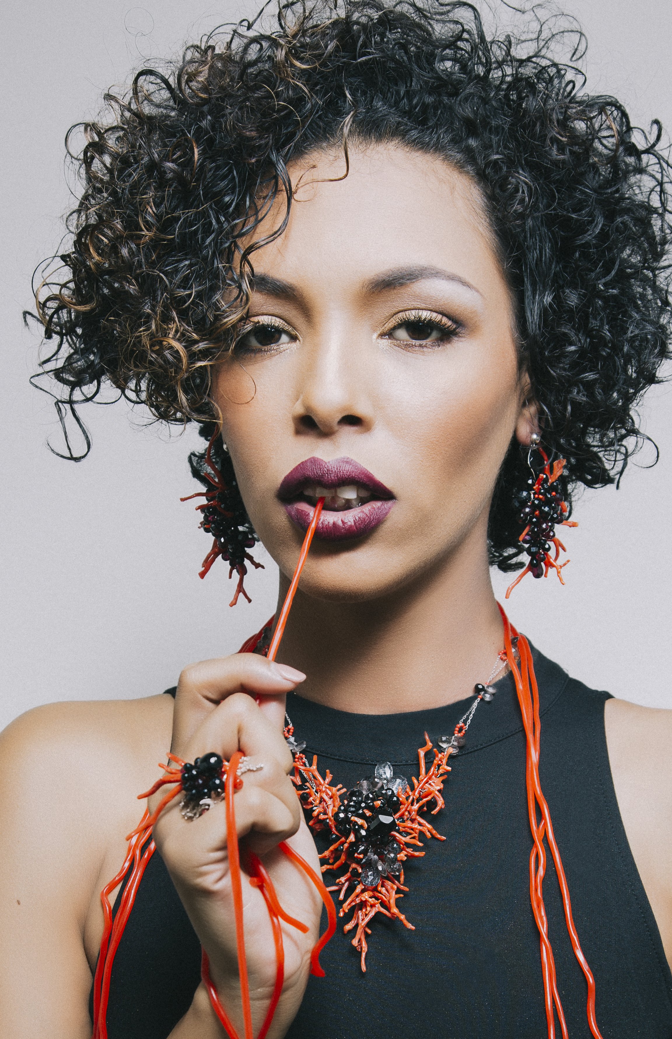 model with red licorice and red coral necklace