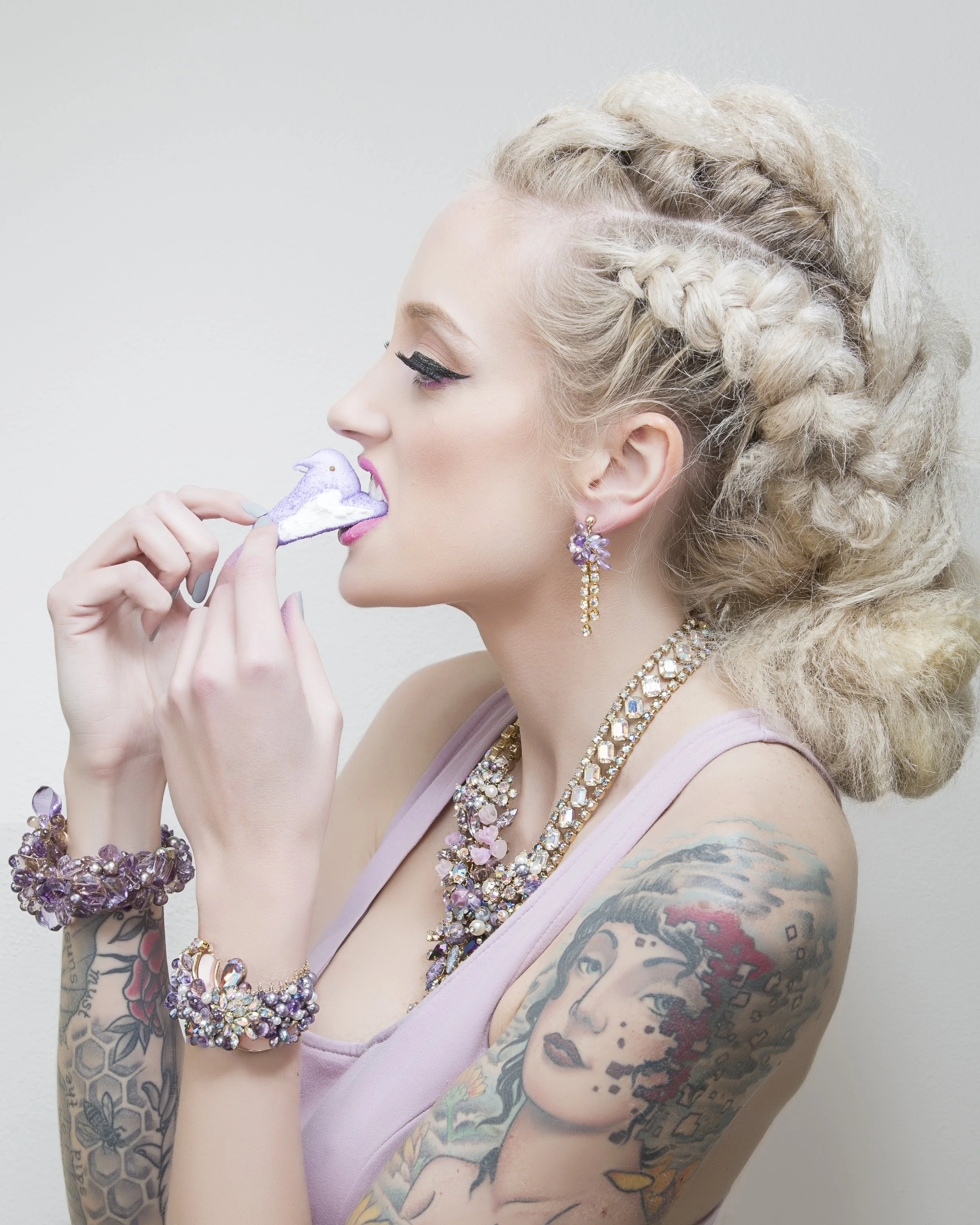 model eating purple marshmallows wearing statement jewelry 