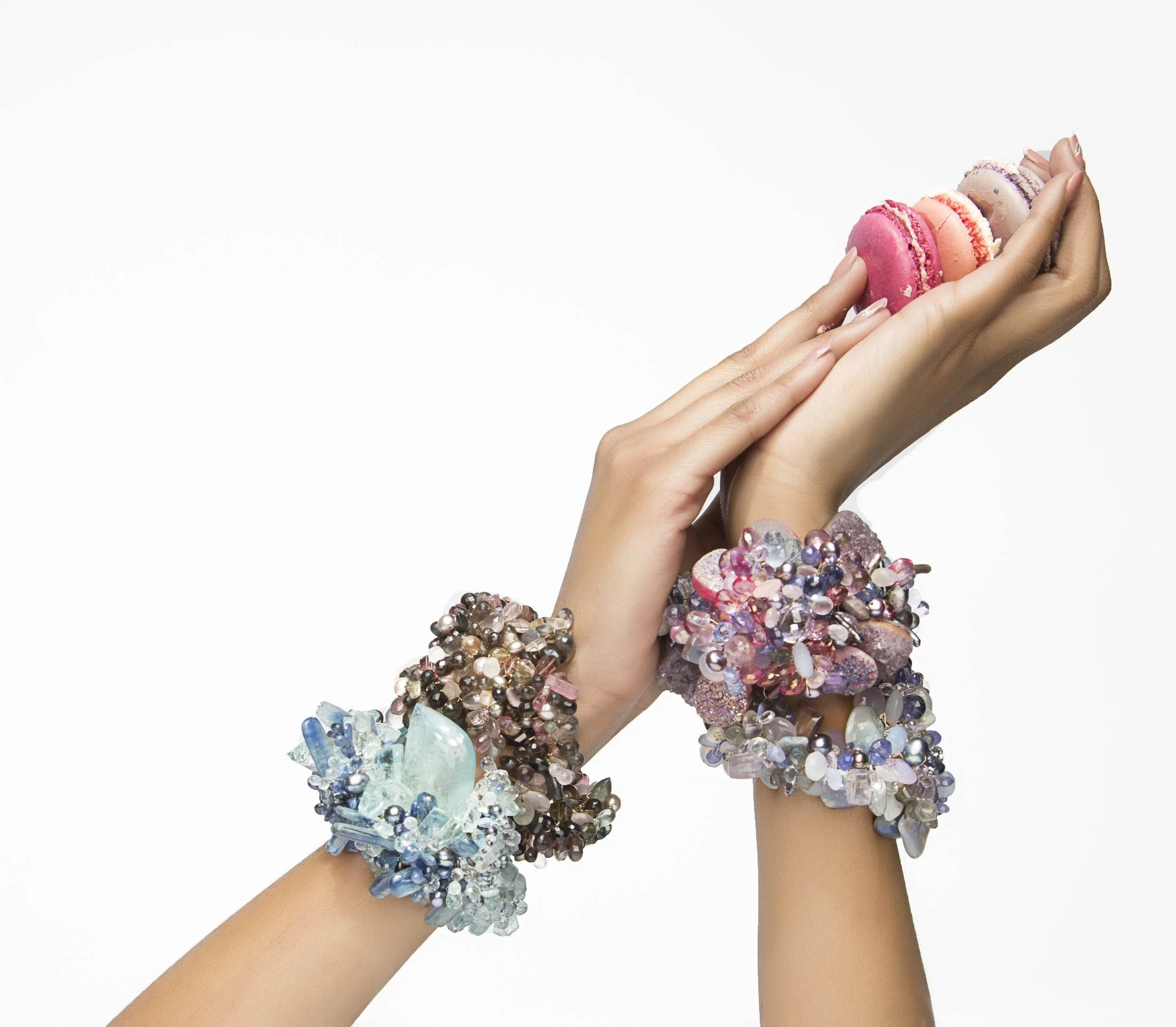 model holding pink macaroons wearing statement gemstone bracelets