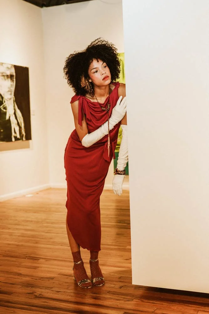 Model in an art gallery for an editorial fashion shoot with tourmaline jewelry