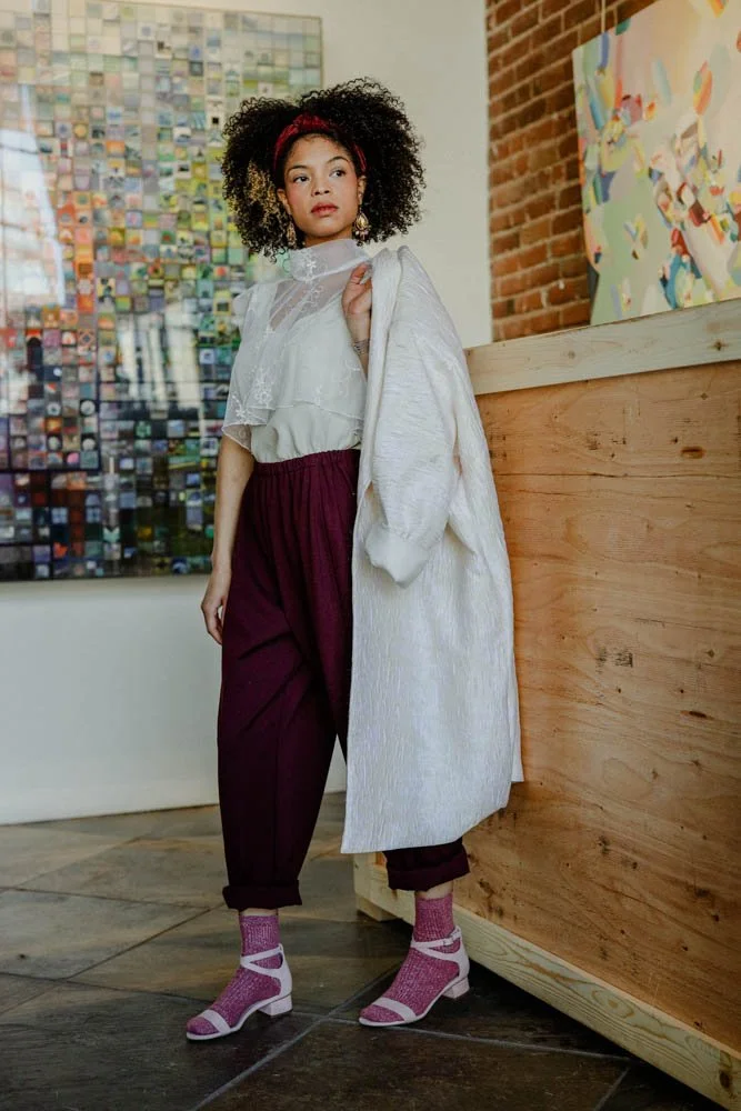 Model in an art gallery for an editorial fashion shoot with tourmaline jewelry