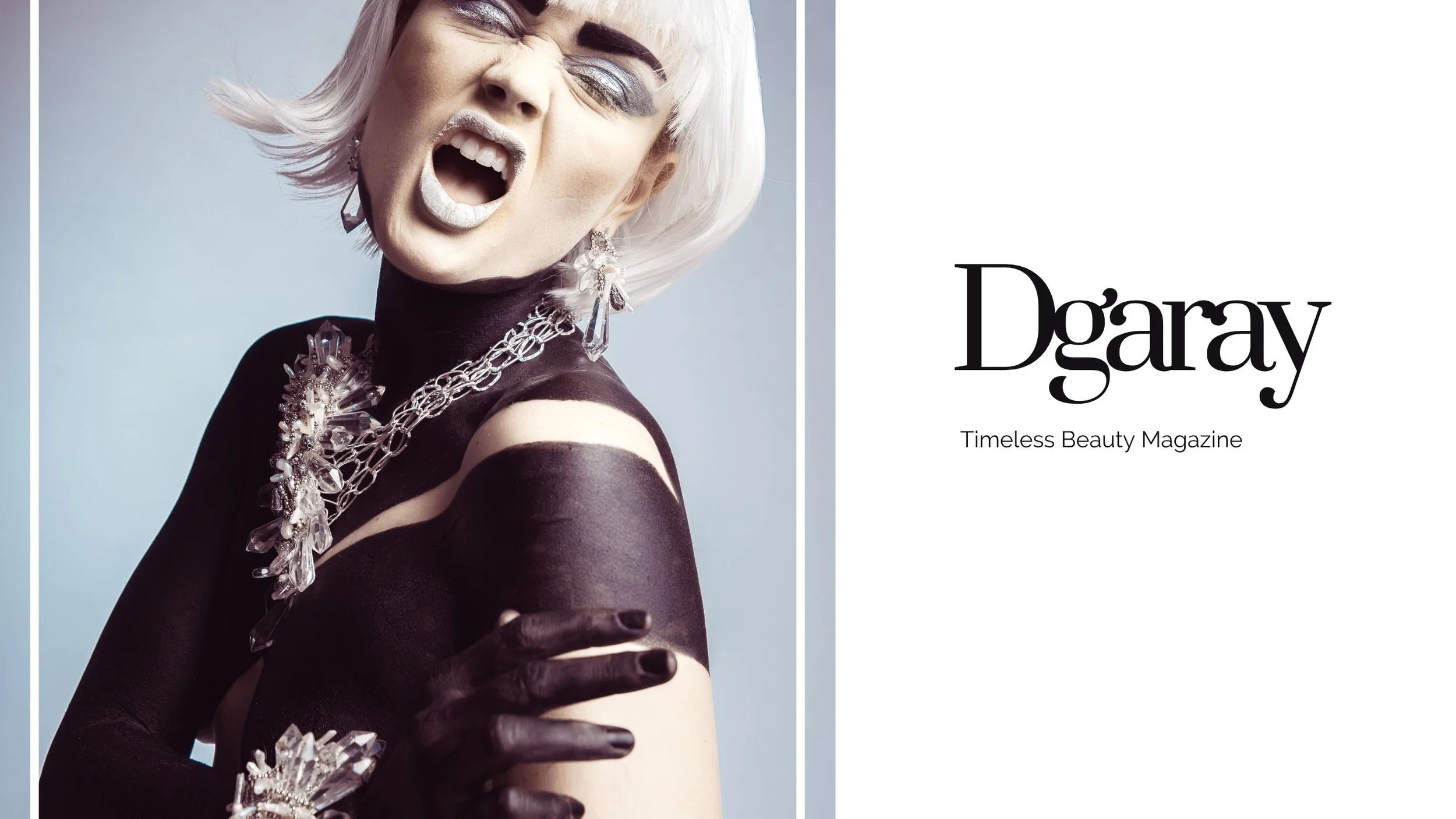 Editorial portrait of a model with a platinum bob, silver makeup, black body paint, and dramatic crystal statement jewelry.