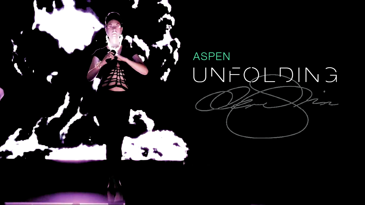 Dark runway image of a model in a black cutout outfit beneath the title “Aspen Unfolding” and a large handwritten signature.