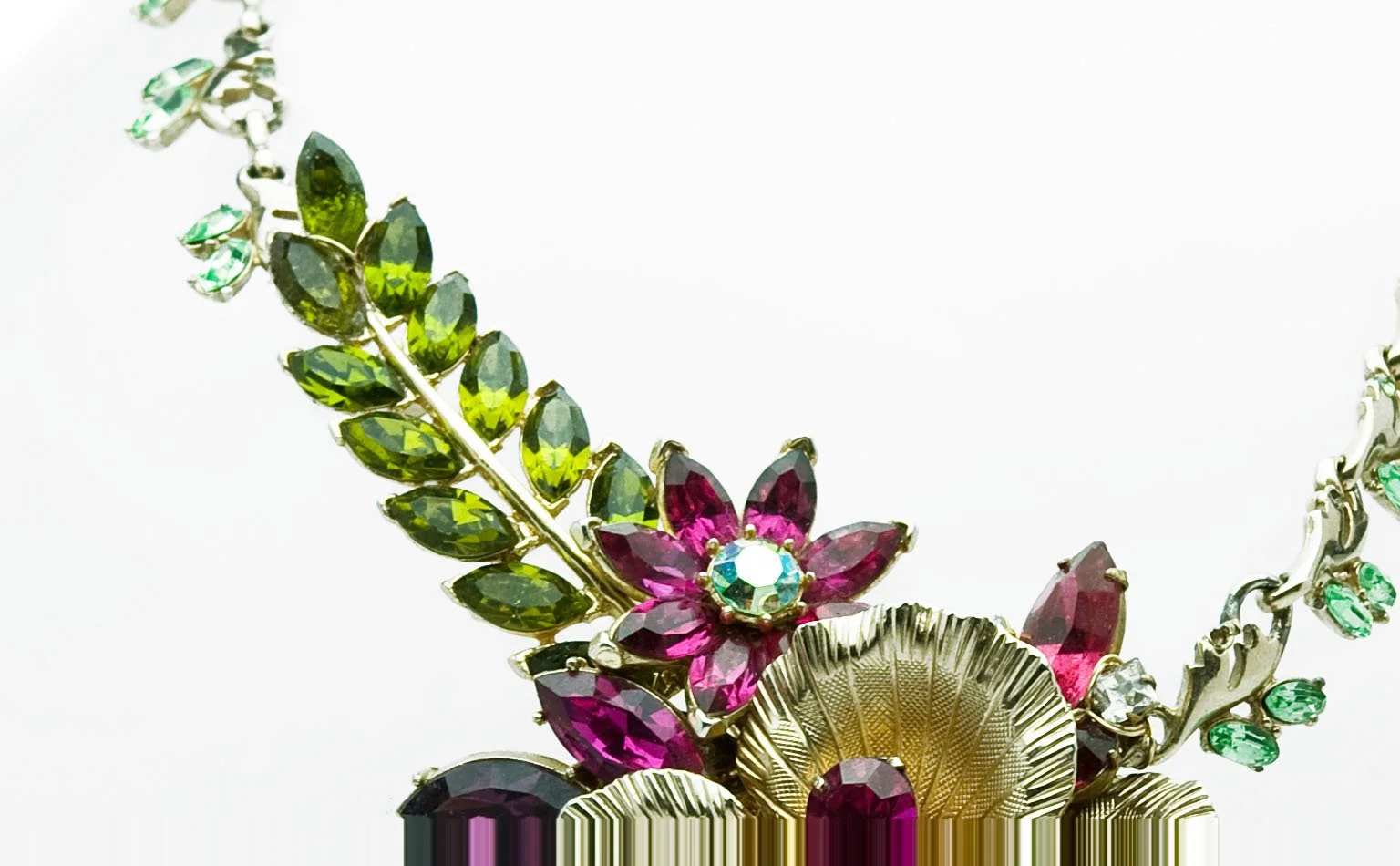 Detail of olive and green navette leaves beside a fluted gold fan