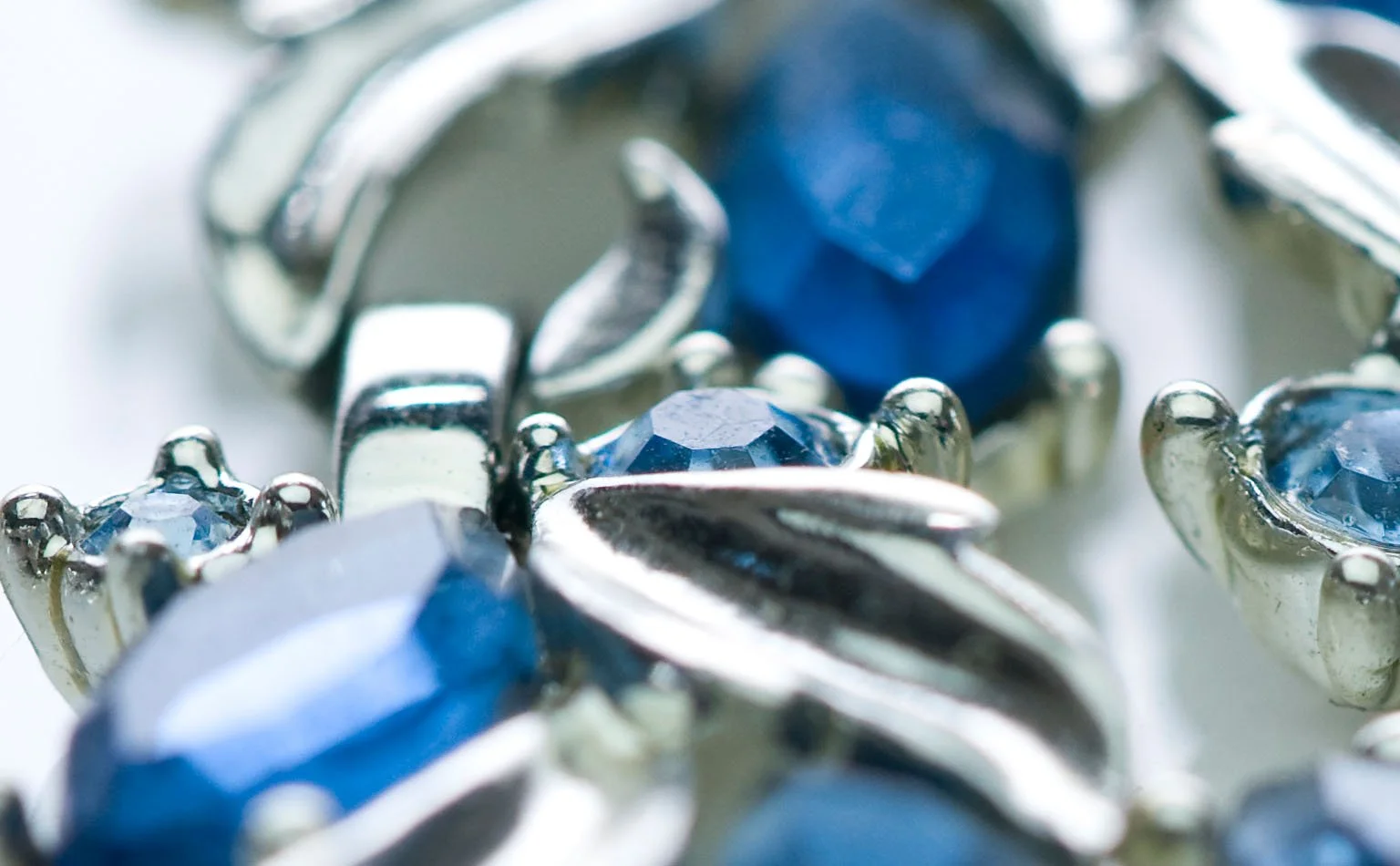 Detail of sapphire-blue navette crystals set among silver leaves