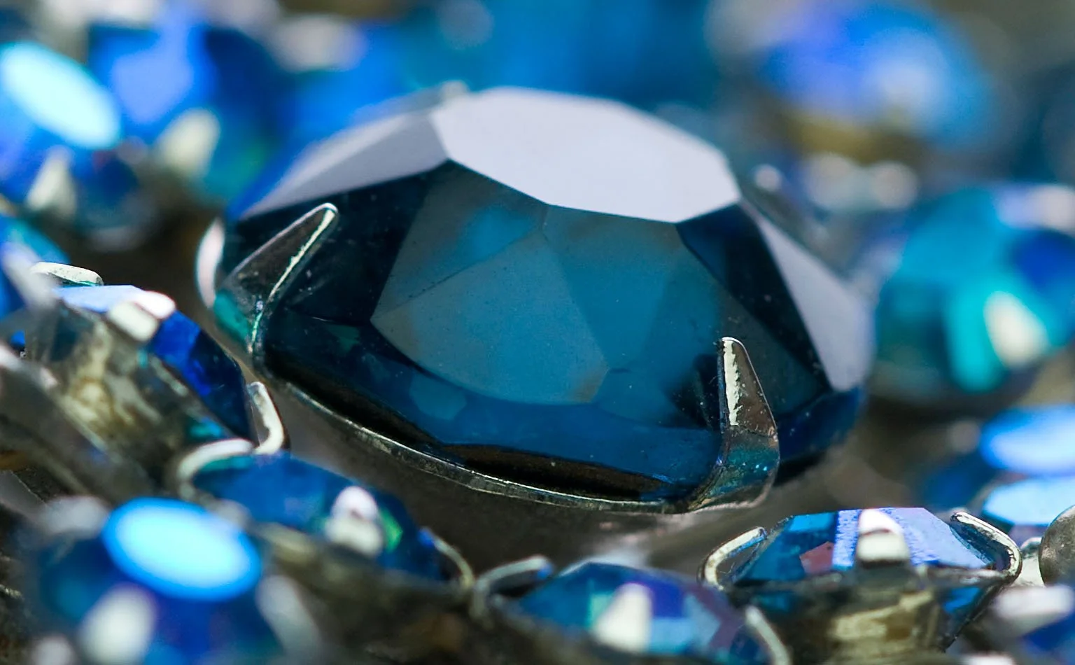 Detail of a large faceted deep-blue crystal in a prong setting 