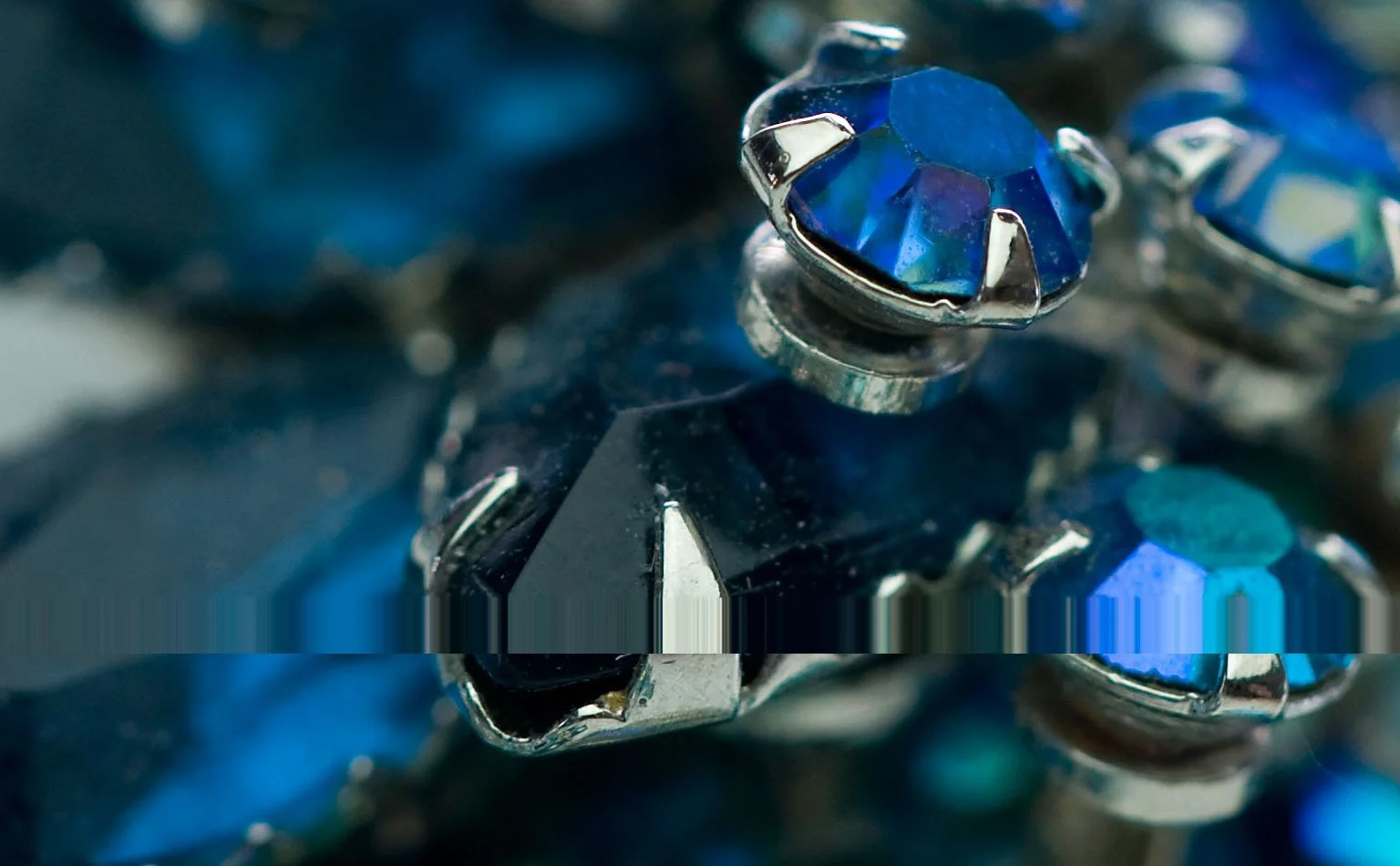 Detail of dark blue faceted crystals in silver-tone claw settings 