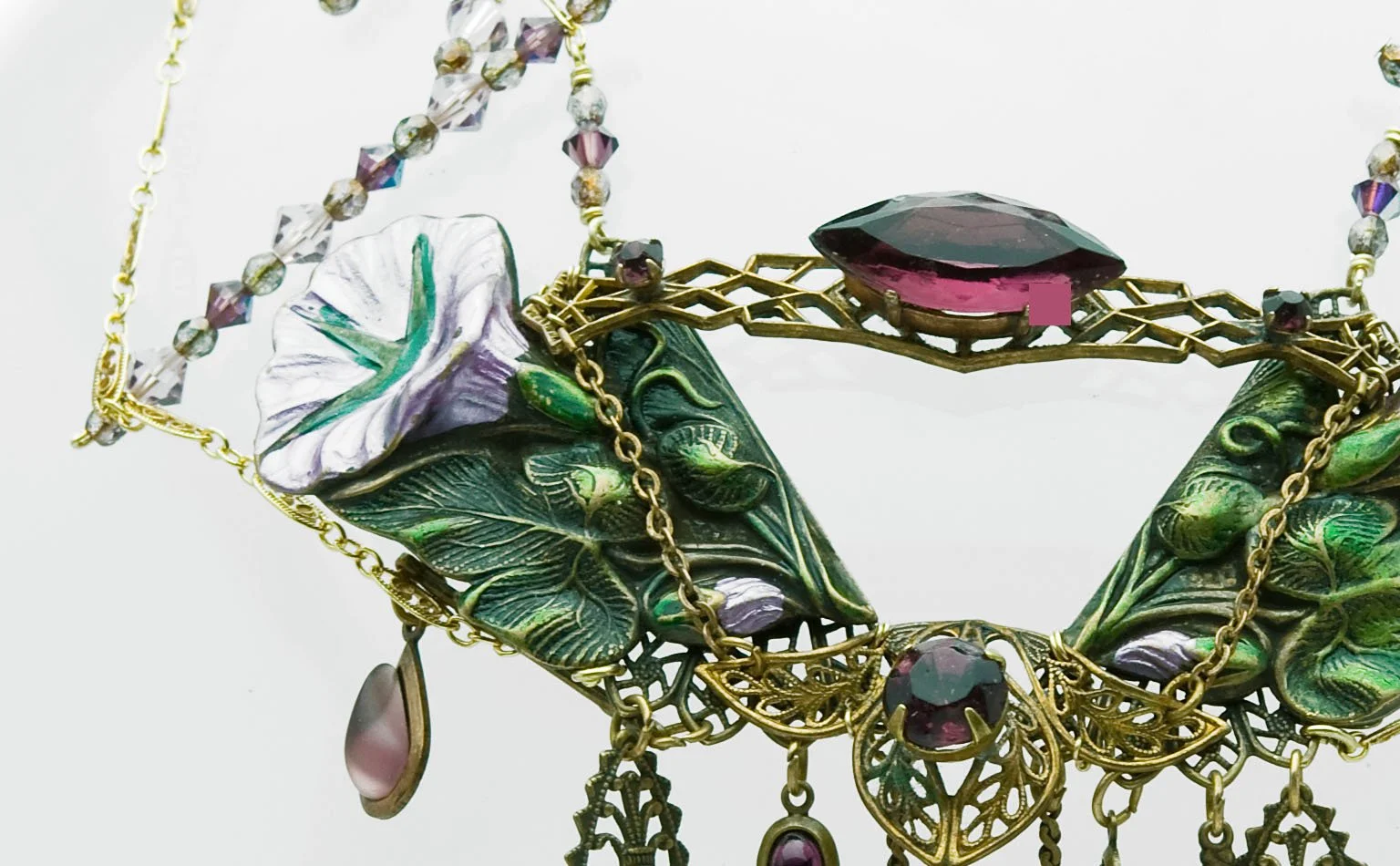 Green enamel leaf necklace centered on a faceted amethyst crystal