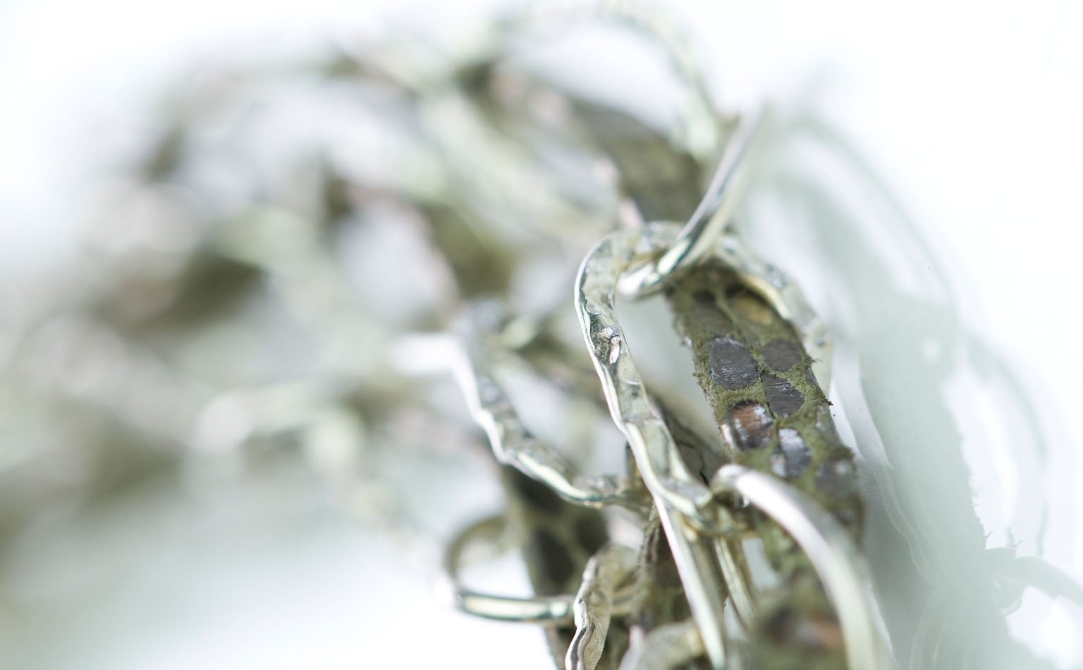 Soft-focus detail of silver-tone chain and clear crystal 